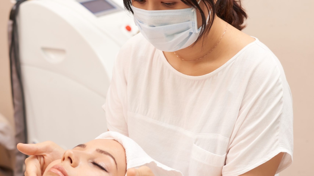 asian-cosmetician-giving-caucasian-client-face-massage